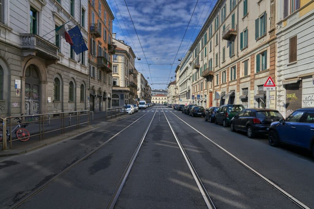 cars parked on side of the road in between buildings during daytime