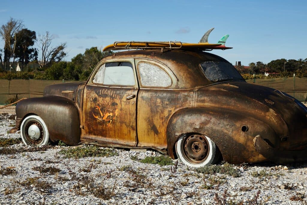 Vintage rusty broken car on gravel