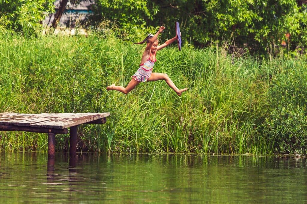 woman in bikini lying on wooden dock during daytime