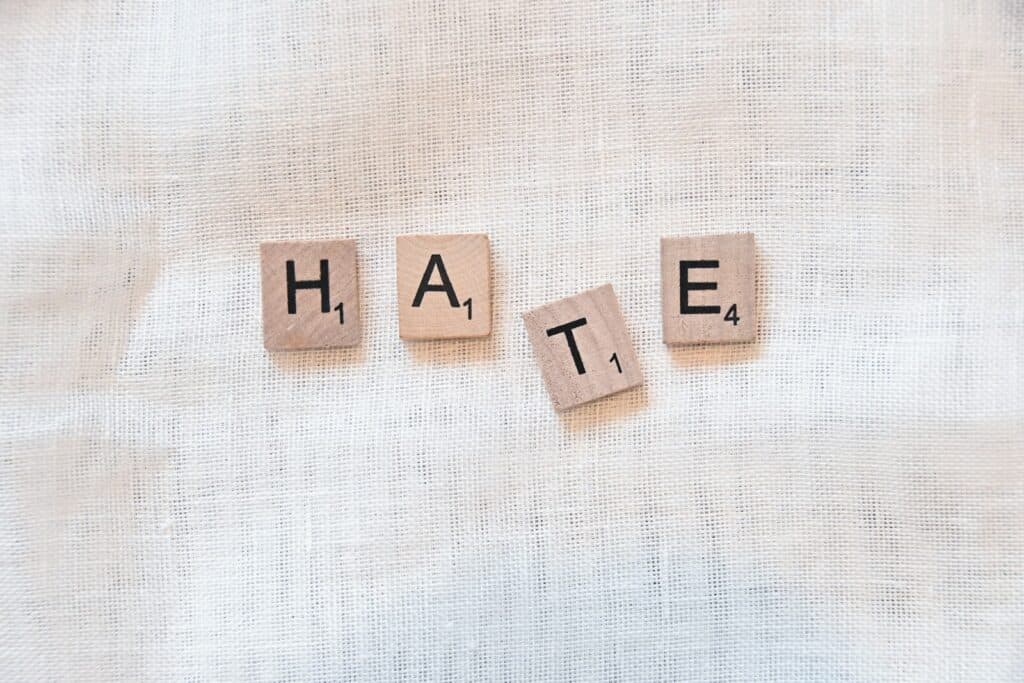 the word hate spelled with scrabbled wood blocks