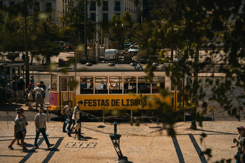 A group of people walking across a street next to a yellow bus