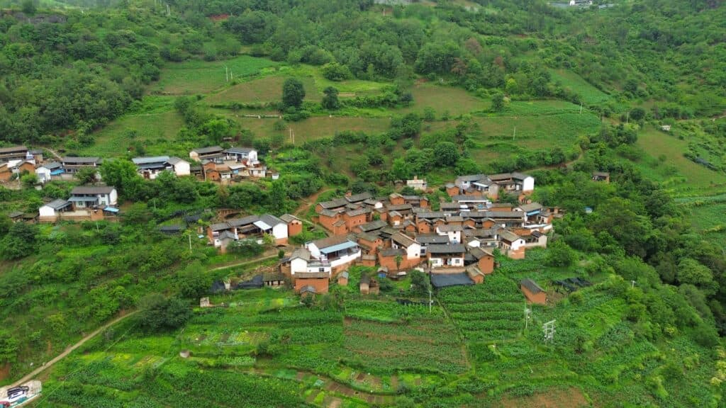 an aerial view of a village surrounded by lush green hills