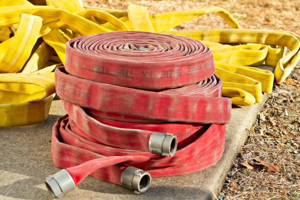 a pile of fire hoses sitting on top of a cement slab