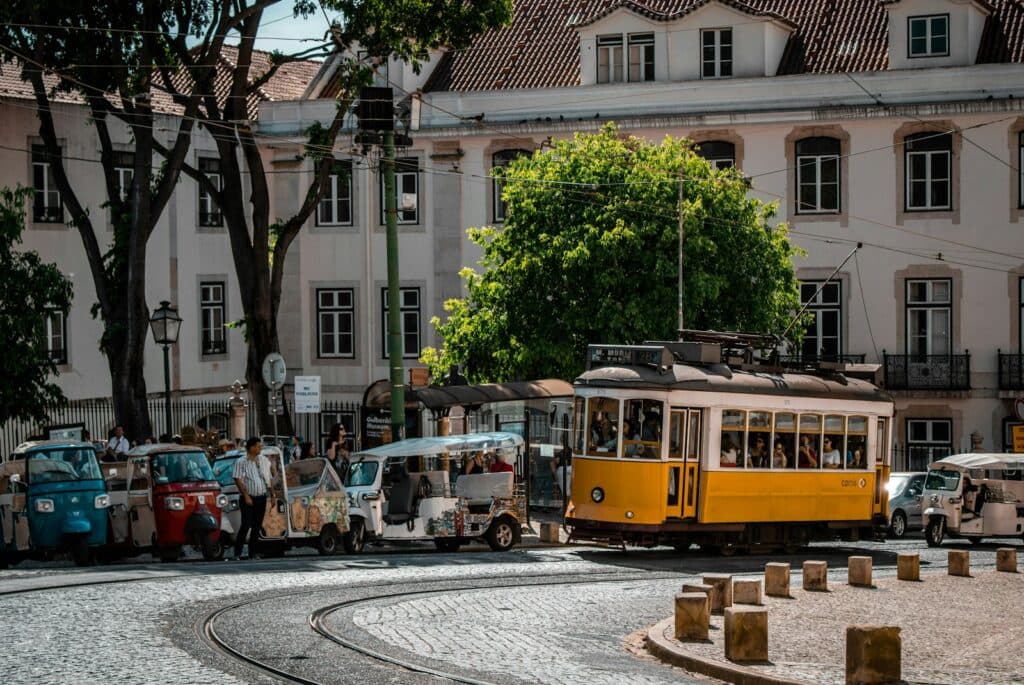 people riding yellow tram on road near building during daytime