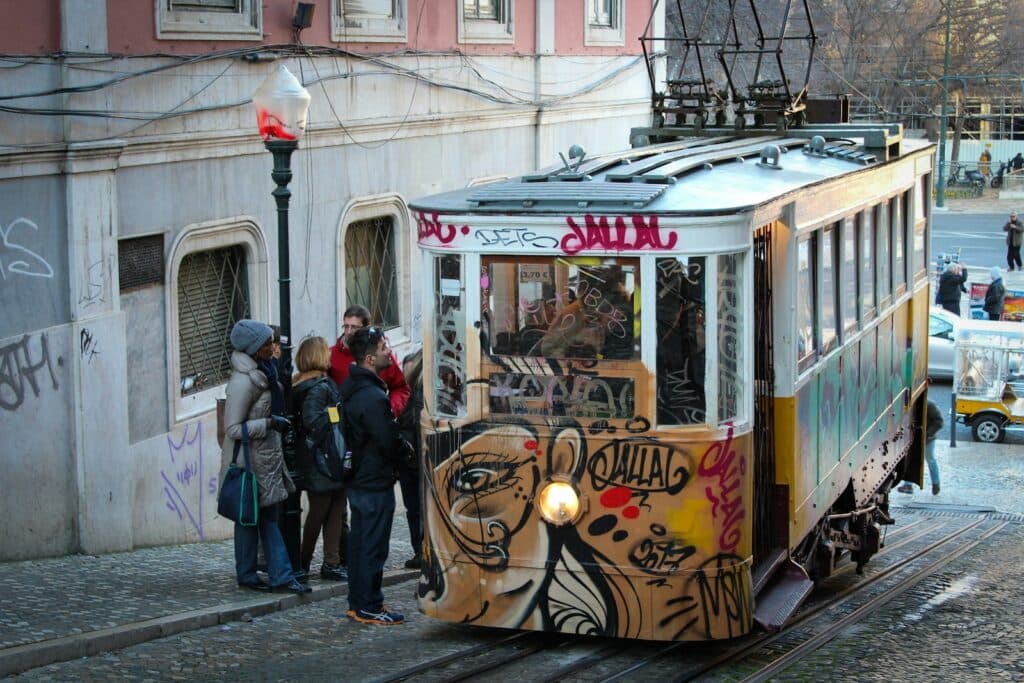 people standing beside yellow and white tram during daytime