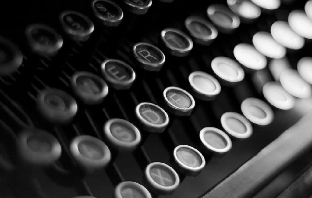 Close-up shot of vintage typewriter keys in black and white, highlighting classic technology.