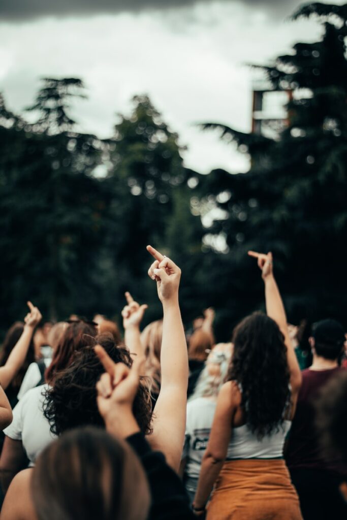 people raising their hands during daytime