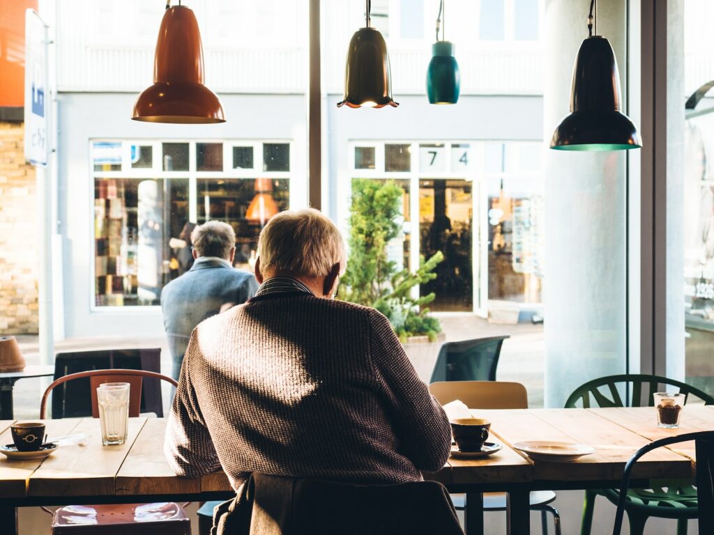 man in chair with table beside coffee