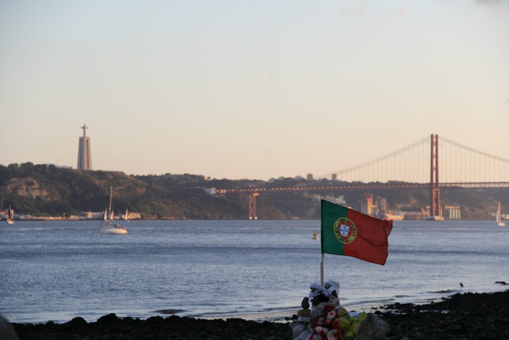a flag on a beach with a bridge in the background