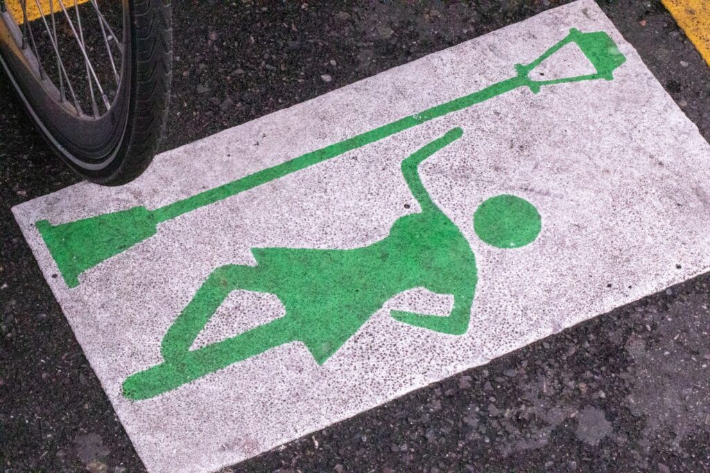 a green and white sign on the ground next to a bike