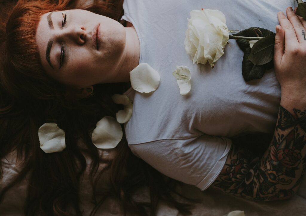 woman sleeping holding white rose flower