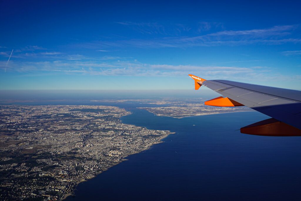 an airplane wing flying over a large body of water