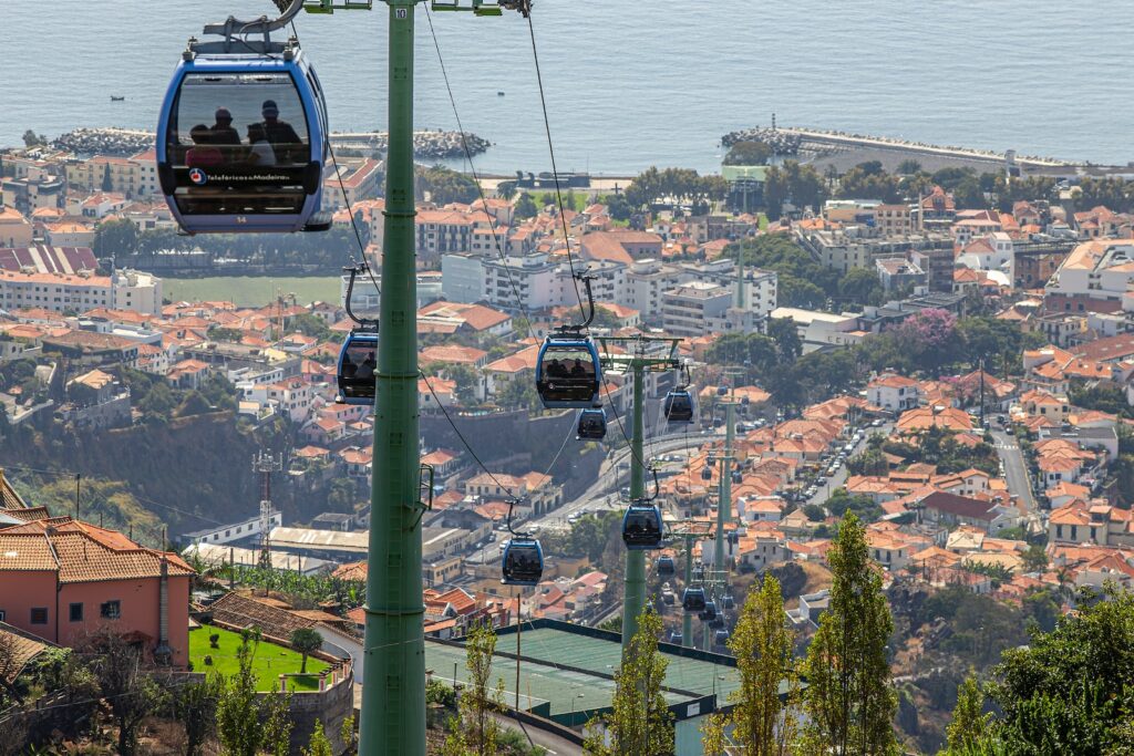 a couple of people riding a ski lift over a city