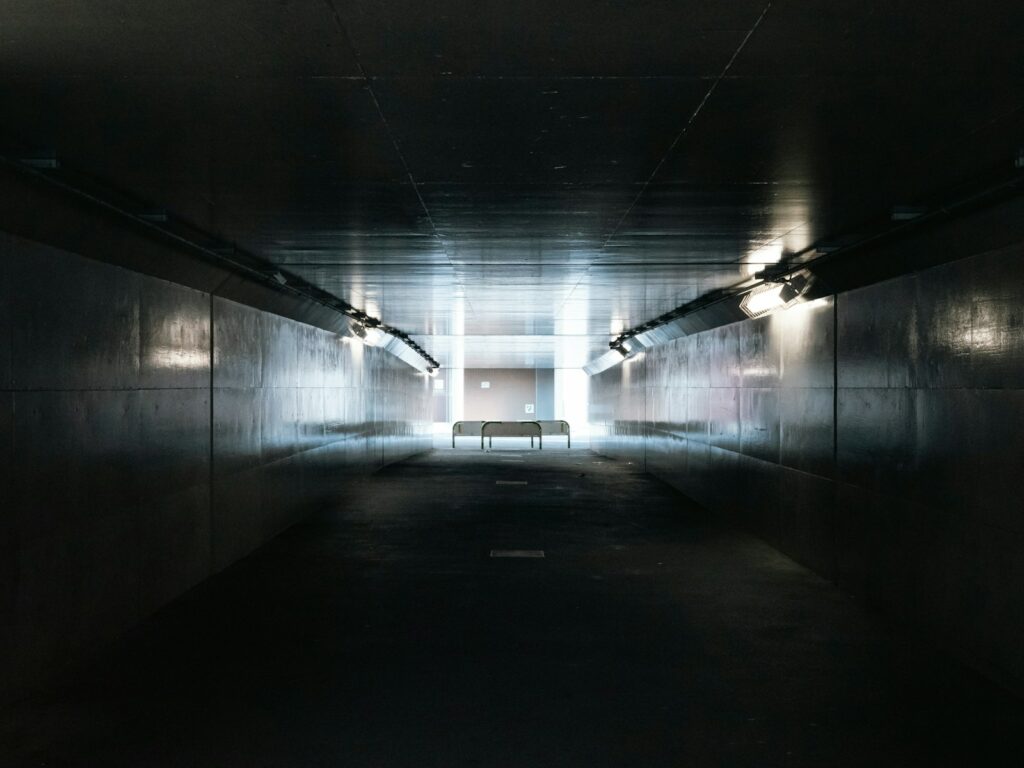 a dimly lit tunnel with a bench in the middle