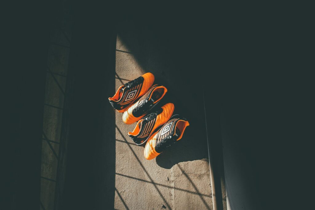 two pairs orange-and-black Umbro shoes